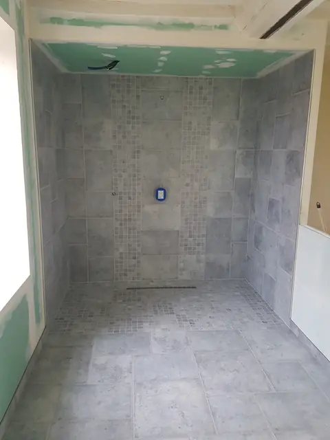 Douche à l’italienne carrelée, murs et sol en carreaux gris